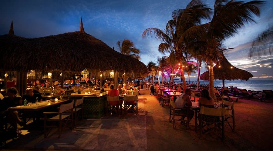Beach club restaurant at night on Zanzibar with palm trees, string lights and ocean views